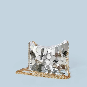 Detail of silver sequin crossbody bag with gold chain strap and secure zipper closure