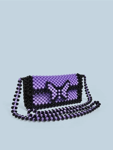Detailed close-up of handmade purple beaded crossbody bag featuring butterfly pattern