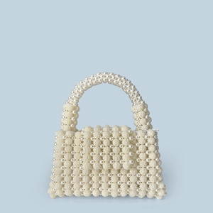 Detail of handmade pearl beaded handbag with premium woven texture and top handle