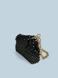 Detail der schwarzen geflochtenen Tasche mit Pyramiden-Nieten und goldener Kette