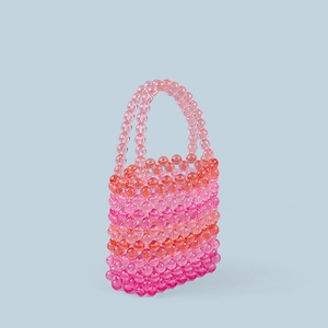 Detailed macro shot of handcrafted pink and orange acrylic beaded mini handbag texture