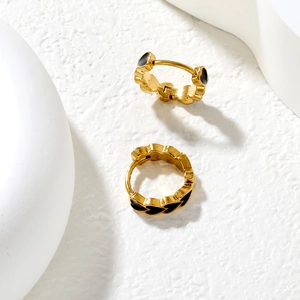 French style gold-plated hoop earrings with black enamel hearts on textured background