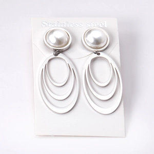 Close-up of gold-plated stainless steel earrings with white pearl and oval hoops