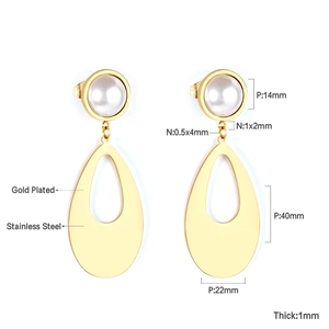 Détail des boucles d'oreilles en acier plaqué or 18K avec perle blanche et pendentif goutte