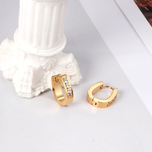Boucles d'oreilles huggie ovales dorées en acier inoxydable avec quatre zircons