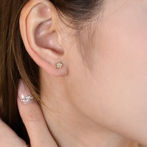 Minimalist 18K gold star stud earrings with sparkling cubic zirconia on female model