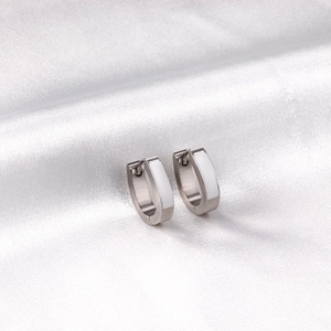 Détail des boucles d'oreilles en U en acier argenté avec incrustation d'émail blanc