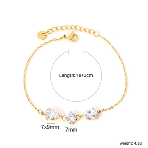 Detail of gold stainless steel bracelet with three clear teardrop and round zircons
