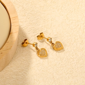 Elegant gold-plated heart drop earrings with pave emerald cubic zirconia on beige surface