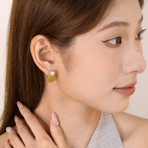 Elegante 18K vergoldete Ohrstecker mit Perle und Streifenmuster auf weiblichem Modell