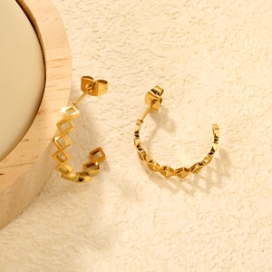 Detail view of 18K gold hollow geometric heart earrings with a mirror polished finish