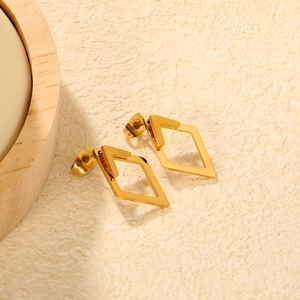 Macro detail of geometric hollow diamond stud earrings in 18K gold plated stainless steel