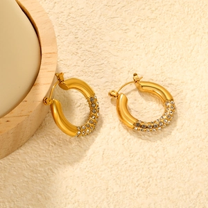 Detail of gold-plated stainless steel earrings with sparkling white cubic zirconia