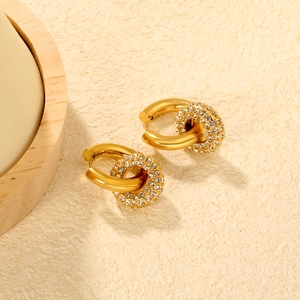 Detailed close-up of gold-plated hoop earrings with crystal-encrusted intertwined ring