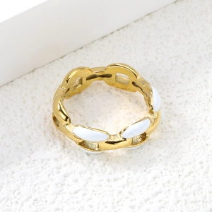 Détail d'une bague en chaîne ajourée plaquée or 18K avec touches d'émail blanc chic