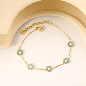 Detail of 18K gold-plated stainless steel bracelet with blue floral charms and lobster clasp