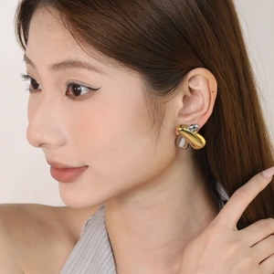 Vue détaillée des boucles d'oreilles bicolores or et argent portées par un mannequin