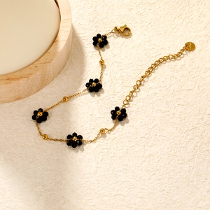 Bracelet chic en acier inoxydable doré avec délicates fleurs perlées noires et fermoir