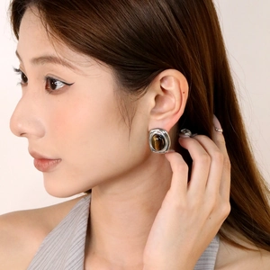 Vintage oval tiger eye stud earrings with polished silver metal finish on a model