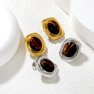 Macro shot of oval tiger eye stones set in vintage gold and silver metal stud earrings