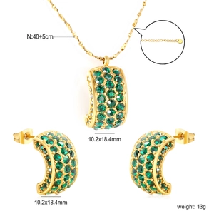 Detail view of gold stainless steel necklace and earrings with emerald green zircon