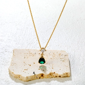 Luxury gold necklace with square clear crystal and pear-cut emerald green gemstone pendant