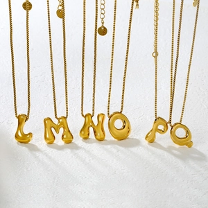 Macro shot of gold puffy alphabet pendants L to Q showing high-polished mirror finish