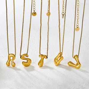 Detailed view of bubble initial pendants R to V on golden stainless steel box chains