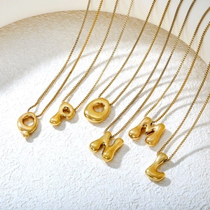 Close-up of golden puffy bubble letter pendants Q to L on square box chains