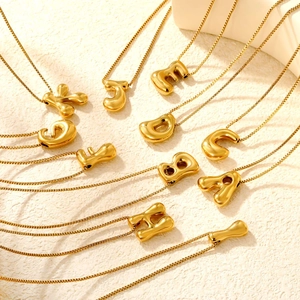 Detail of 3D bubble letter pendants in polished gold finish with fine link chains