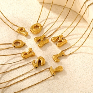 Detail of 3D bubble letter necklaces in gold finish with mirror surface and box chains