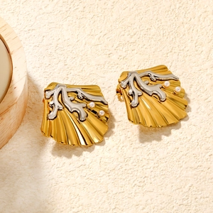 Boucles d'oreilles coquillage doré avec corail argenté et perles sur fond beige