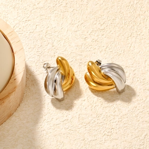 Détail de boucles d'oreilles créoles torsadées bicolores or et argent polies
