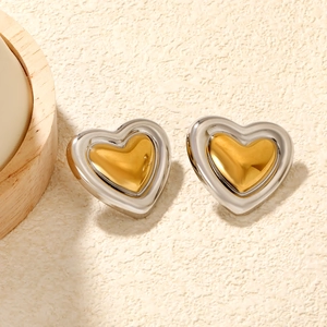 Détail de boucles d'oreilles en forme de cœur avec un design bicolore or et argent