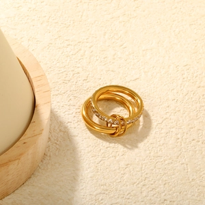 Zweilagige goldene Edelstahlringe mit Zirkonia-Steinen und verbindenden Metallringen