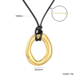 Detail view of irregular gold hollow pendant with size specs and black wax cord necklace
