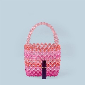 Detailed shot of handmade rainbow acrylic beaded tote bag with lipstick for scale