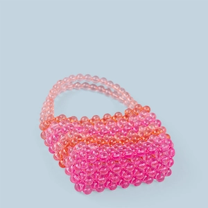 Detailed close-up of handmade pink gradient acrylic beaded mini bag with woven texture