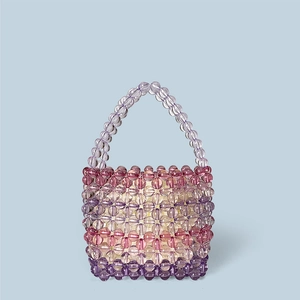 Detail of handmade beaded tote bag featuring transparent pink and purple acrylic beads