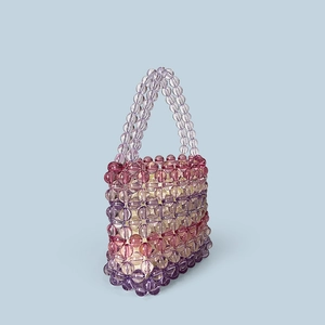 Detailed view of handmade rainbow beaded bag with clear acrylic beads in purple gradient