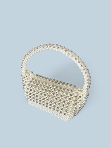 Close-up detail of handcrafted white pearl woven handbag with sparkling crystal rhinestones