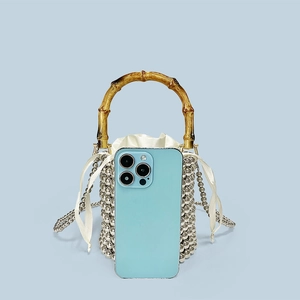 Detailed view of beaded bucket bag with bamboo handle and drawstring inner pouch