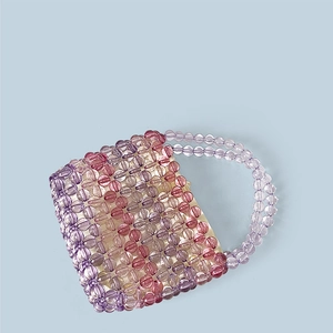 Detail of handcrafted rainbow acrylic beaded tote bag with purple and pink floral patterns