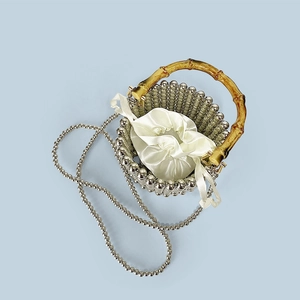 Detail of woven silver beaded bucket bag with bamboo handle and drawstring lining