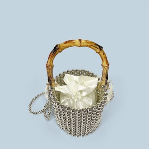 Detailed view of beaded bucket bag with bamboo handle and drawstring satin liner