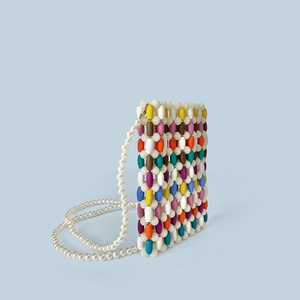 Detail showing colorful wooden beads texture and glossy white pearl chain strap