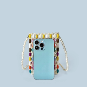 Close-up of colorful wooden bead pattern with pearl strap holding a smartphone