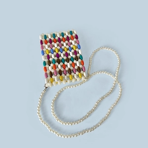 Detail of colorful wooden beads pattern and white pearl strap on mini crossbody phone bag