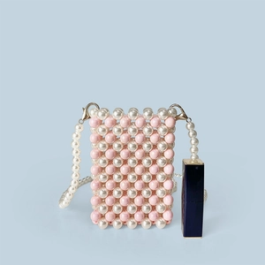 Detailed view of mini pink beaded bag with lipstick for scale and golden metal clips