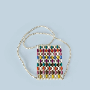 Macro shot of colorful wooden beads and white pearls on a mini crossbody phone bag